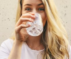 why water is important: a woman happily drinking fresh water